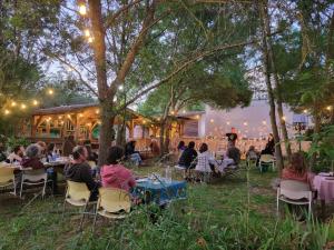 a group of people sitting at tables in the grass at Le Mas Mouth in Montoulieu