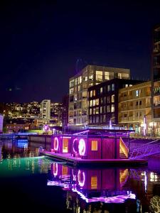 a lit up house in the water at night at TotalApartments Vervet Fram in Tromsø
