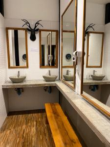 a bathroom with three sinks and mirrors and a wooden bench at Bloom Cafe & Hostel in Ko Lipe +33 photos