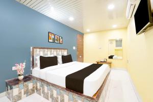 a bedroom with a large bed and a blue wall at Hotel O Pragati in Jairāmpura