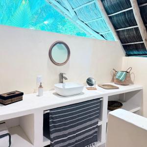 a bathroom with a sink and a mirror on a counter at Casa Mar Beachfront Jungle Villa in Palapa Ganesh in Sayulita
