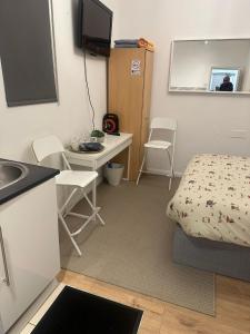 a small room with a bed and a desk and a sink at Comfy stay, Stockwell SW9 in London