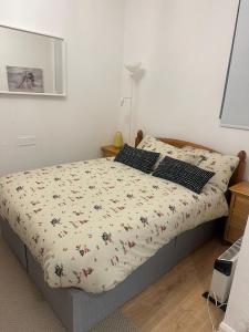 a bedroom with a bed with a floral bedspread at Comfy stay, Stockwell SW9 in London
