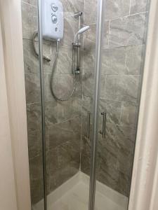 a shower stall with a glass door with a shower at Comfy stay, Stockwell SW9 in London
