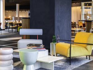 a room with chairs and a table with books at Tribe Amsterdam City in Amsterdam