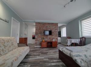 a living room with a couch and a brick fireplace at Przytulne i ciepłe mieszkanie w spokojnej dzielnicy Opola in Opole +10 photos