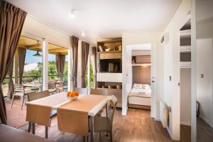 a dining room with a table and a bedroom at Valamar Camping Krk in Krk +43 photos