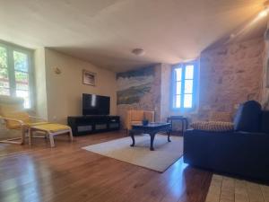 una sala de estar con un sofá y una mesa en La Nit de la Fontaine, en Brossac