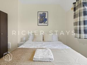 ein Schlafzimmer mit einem großen Bett mit weißer Bettwäsche in der Unterkunft Spacious 3BR House in Tilbury, Driveway and Garden in Tilbury