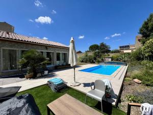 un patio con sombrilla y piscina en Sous les toits, en Canet d'Aude
