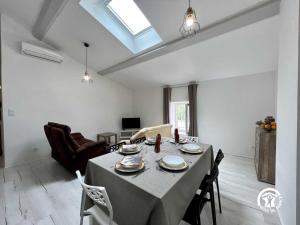 Un comedor con una mesa y sillas en una habitación. en Sous les toits, en Canet d'Aude