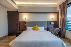 a bedroom with a large white bed and a desk at Weston Suites Hotel in Santo Domingo