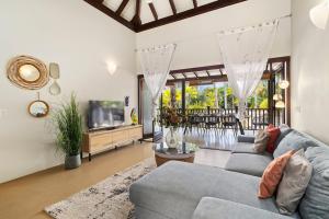 ein Wohnzimmer mit Sofa und Fernseher in der Unterkunft 3bdr, with tropical garden & pool in Kralendijk! in Kralendijk