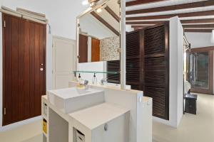 ein Badezimmer mit einem weißen Waschbecken und einem Spiegel in der Unterkunft 3bdr, with tropical garden & pool in Kralendijk! in Kralendijk + 28 Fotos