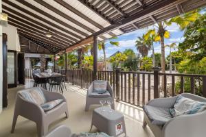eine Terrasse mit Stühlen und einem Tisch auf einem Balkon in der Unterkunft 3bdr, with tropical garden & pool in Kralendijk! in Kralendijk