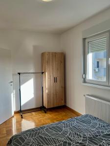 Un dormitorio con una cama y un armario de madera. en Apartman Kalina, en Belgrado