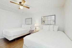 una camera bianca con 2 letti e un ventilatore a soffitto di Horizon South 23D a Panama City Beach Altre 19 foto