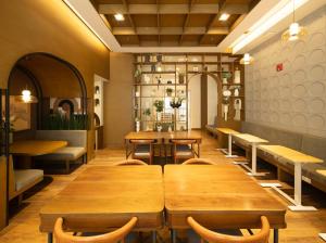 a restaurant with wooden tables and benches in a room at The Retrograde at The Crestmont in Manila