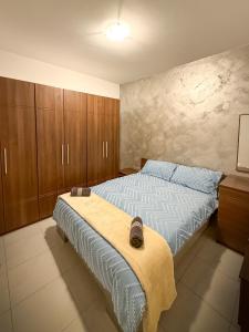 a bedroom with a bed and wooden cabinets at Spacious Peaceful Apartment - Tarxien in Tarxien