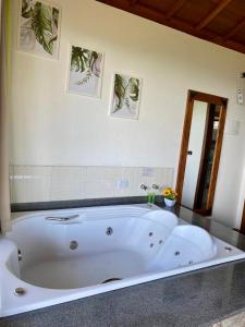 a large white bath tub in a room at Chalés Terras Altas in Gonçalves