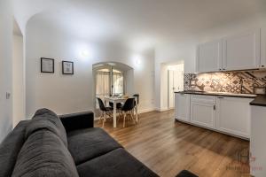 a living room with a couch and a kitchen with a table at paleocapa 6 bilocale in Savona +25 photos