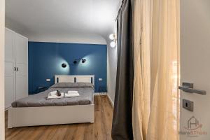 a bedroom with a blue accent wall and a bed at paleocapa 6 bilocale in Savona