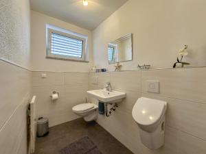 a white bathroom with a toilet and a sink at Hasn Res in Kleinwinklarn +25 photos