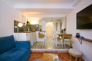 a living room with a blue couch and a kitchen at Romantic getaway in Bormes in Bormes-les-Mimosas