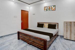 バラナシにあるHotel O Ujala Guest Houseのベッドルーム1室(木枠のベッド1台付)