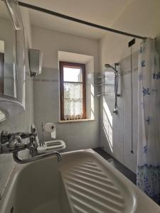 a bathroom with a tub and a sink and a window at La Terrazza di Maria in Pienza