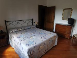 a bedroom with a bed and a dresser and a mirror at La Terrazza di Maria in Pienza