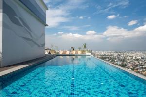 a swimming pool on the roof of a building with a city at The Retrograde at The Crestmont in Manila