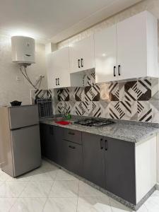 Una cocina con gabinetes blancos y encimera. en Oualidia city, en Oualidia
