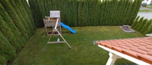 une aire de jeux avec une balançoire et un toboggan bleu dans l'établissement Ferienhaus Fuchs, à Neukirchen vorm Wald