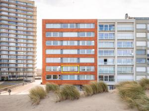 een hoog rood bakstenen gebouw naast een strand bij Manderley tweede in Oostduinkerke-Bad