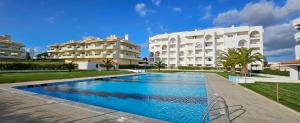 a swimming pool in front of a building at Apartamentos Vista Mar in Armação de Pêra