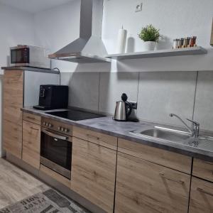 een keuken met een spoelbak en een fornuis bij Ferienwohnung Lüchtringen in Höxter