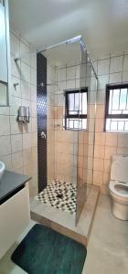 a bathroom with a shower and a toilet at Closer to CBD by UrbanCove in Nelspruit