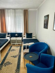 a bedroom with a blue chair and a bed and a couch at Bulevar in Valjevo +20 photos