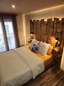 een slaapkamer met een bed met twee kussens erop bij Appartement design et chaleureux en centre ville in Oyonnax