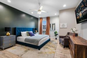 a bedroom with a bed with a blue headboard at Luxury 3-Story Home w Pool & Parking garage in New Orleans