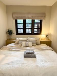 a bedroom with a large white bed with a window at Villa 107 with private patio and balcony in Ban Yang Pa Kha