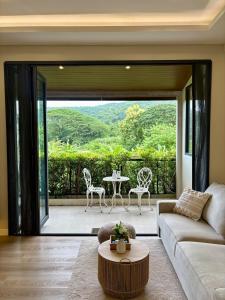 a living room with a couch and a table at Villa 107 with private patio and balcony in Ban Yang Pa Kha