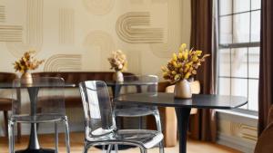 a dining room with tables and chairs with flowers on them at Expansive Lakehouse W Stunning Pool & Views in The Hills