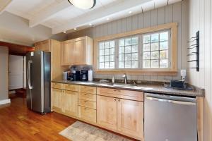 Una cocina con gabinetes de madera y un refrigerador de acero inoxidable. en Four Seasons Lakehouse, en Franklin