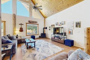 a living room with a ceiling fan and a tv at Riverfront Lodge in Pagosa Springs