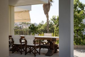 a table and chairs with an umbrella on a patio at Voula Riviera Apartment in Athens