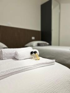 twee handdoeken op een bed met een fles erop bij La Casa Del Viaggiatore in Grassobbio
