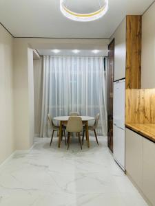 a kitchen and dining room with a table and chairs at K7 Family in Atyraū