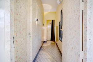 a hallway with white walls with floral wallpaper at Collection O GNRC Hospital Dispur Formerly Shree Vinayak Guest House in Guwahati